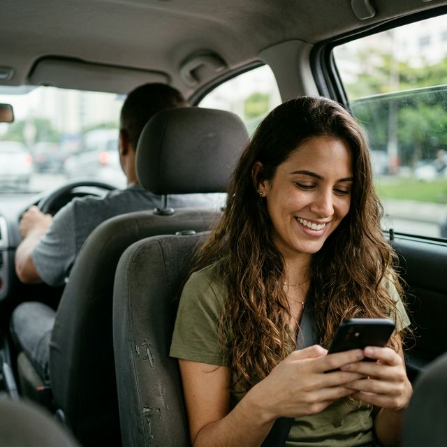Mulher no carro usando o aplicativo ChamaAí